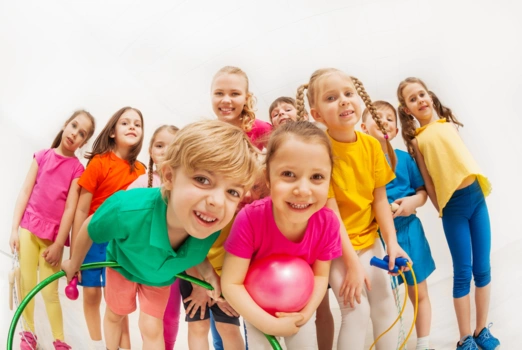 Kindergartenkinder stehen zusammen und lächeln freundlich.