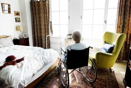 Eine Dame im Rollstuhl sitzt in ihrem Zimmer.