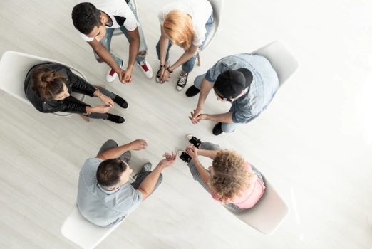 Fünf Menschen sitzen im Kreis uns sprechen miteinander.