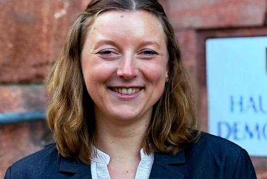 Eva Walle, eine junge Frau mit blondem Haar, lächelt freundlich.