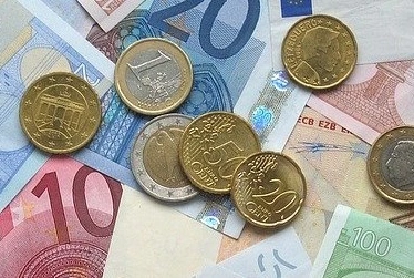 Euro- und Cent-Münzen liegen auf Eurobanknoten verschiedenen Wertes.