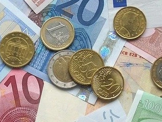 Euro- und Cent-Münzen liegen auf Eurobanknoten verschiedenen Wertes.