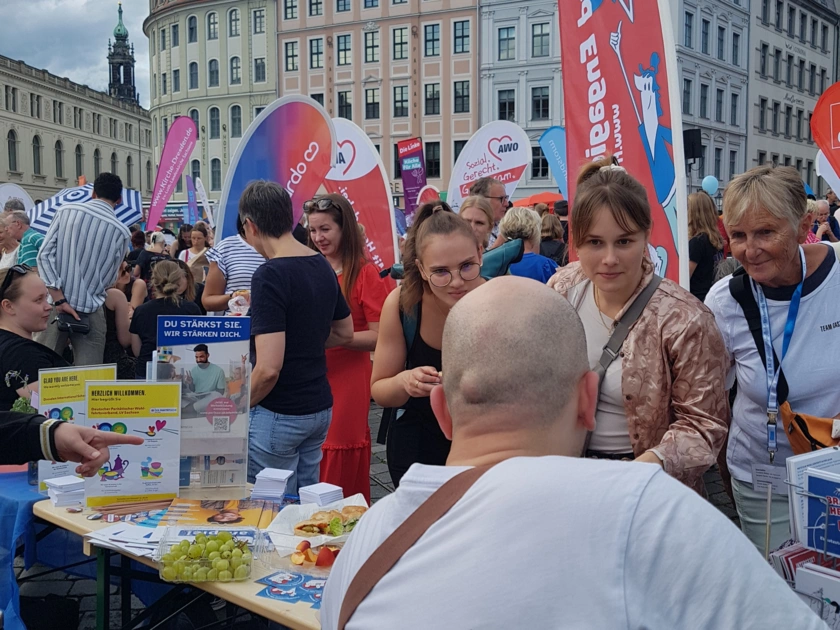 Besucher*innen am stehen an einem Tisch beim Gastmahl auf dem Dresdner Neumarkt.