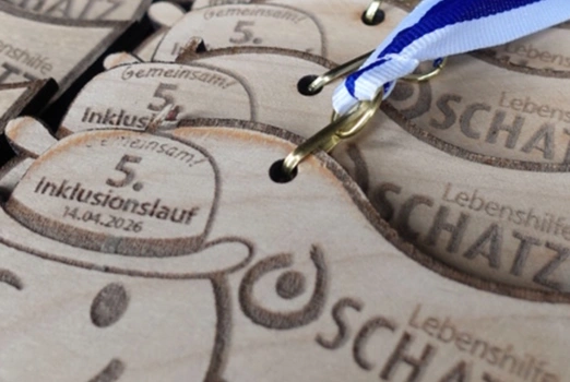 Medaillen für den Inklusionslauf der Lebenshilfe Oschatz 2026 liegen aufgereiht.