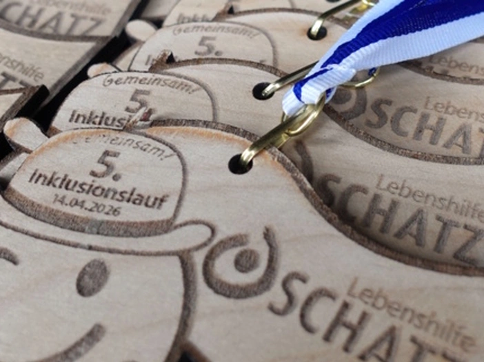Medaillen für den Inklusionslauf der Lebenshilfe Oschatz 2026 liegen aufgereiht.