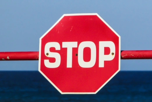 Ein Stoppschild an einer Schranke.