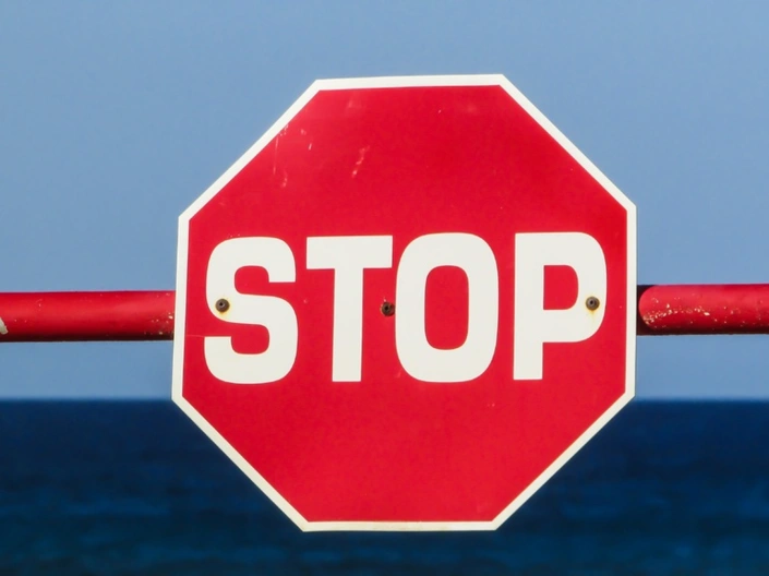 Ein Stoppschild an einer Schranke.