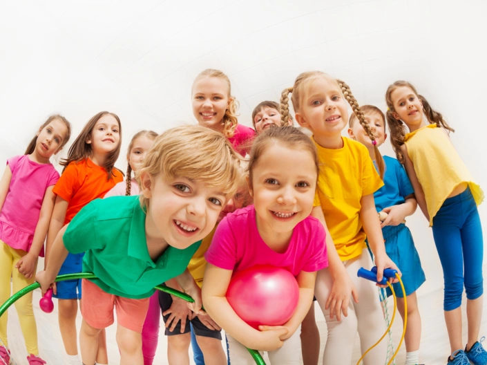 Kindergartenkinder stehen zusammen und lächeln freundlich.