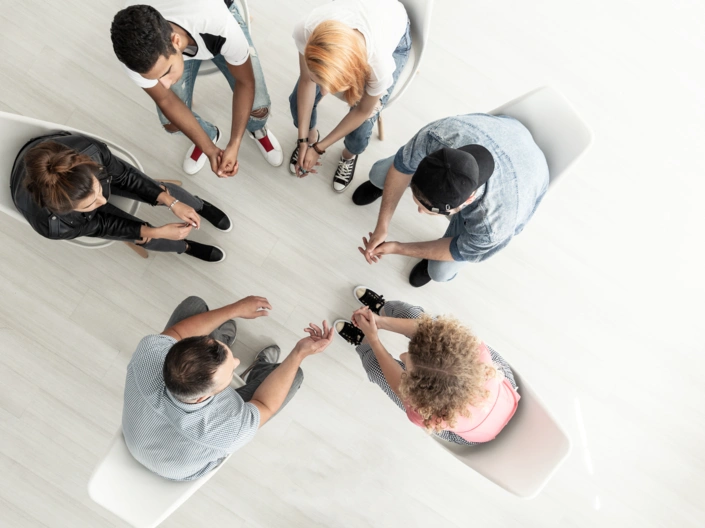 Fünf Menschen sitzen im Kreis uns sprechen miteinander.